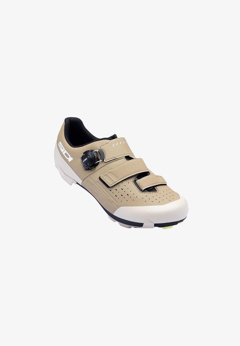 Chaussure de cyclisme beige et blanche avec une semelle en caoutchouc, dotée d'une double bride Velcro, d'une tige en cuir perforé et d'un cadran réglable.