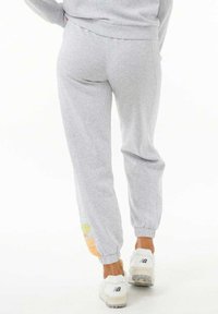 Pantalones de chándal grises hechos de una suave mezcla de algodón, con una cinturilla y puños de canalé, y con acentos rectangulares multicolores cerca del dobladillo.