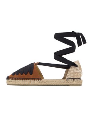 Sandalia espadrille con parte delantera de ante marrón, tacón beige tejido, suela trenzada de yute y largas tiras negras para atar al tobillo.