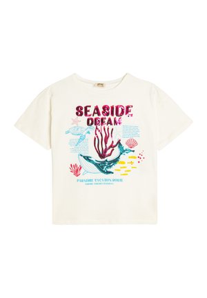 T-shirt en coton blanc à manches courtes avec des graphiques colorés représentant la vie marine, y compris une baleine, des tortues et du corail, avec le texte "RÊVE EN BORD DE MER."