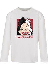 Hosszú ujjú fehér ing, amelyen Cruella de Vil grafika látható fekete és fehér hajjal, mosolyogva, vörös négyzet háttér előtt.