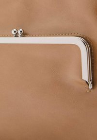 Pochette en cuir tan avec une texture lisse, dotée d'un fermoir en métal argenté et de coutures décoratives le long des bords.