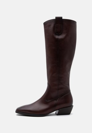 Botte haute en cuir marron foncé avec un bout pointu, un talon bloc et une languette de tirage en haut, sur un fond uni.