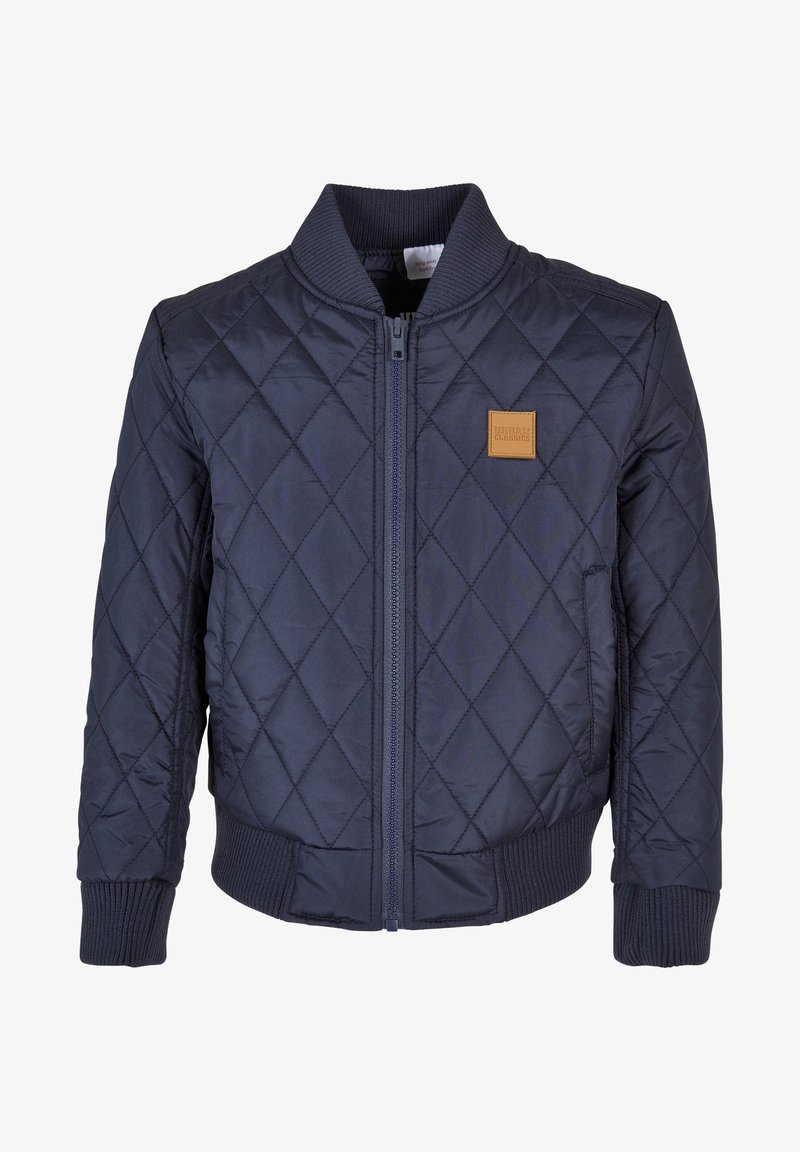 Blouson bomber matelassé bleu marine avec fermeture éclair devant, col, poignets et taille en côtes, et un petit écusson carré marron sur la poitrine.
