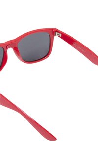 Ochelari de soare din plastic roșu, cu lentile închise la culoare. Cadru de formă pătrată, textură netedă și detaliu metalic la balama. Design ușor.
