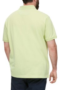 Lichtgroene polo met korte mouwen en een kraag, gemaakt van zacht materiaal, met een rechte zoom en minimalistische ontwerpelementen.