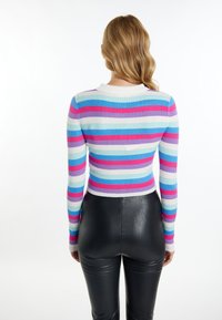 Színes, bordázott, hosszú ujjú kötött felső, pink, kék és levendula csíkokkal, kerek nyakkivágással és testhez simuló fazonnal, fekete leggingszel párosítva.