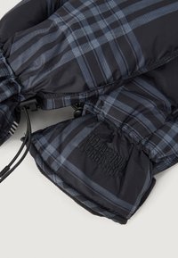 Μαύρα και ναυτικά καρό γάντια με ελαστικές μανσέτες, διαθέτοντας απαλό εσωτερικό φόρεμα και λογότυπο κεντημένο στη μία πλευρά. Ρυθμιζόμενα κορδόνια.