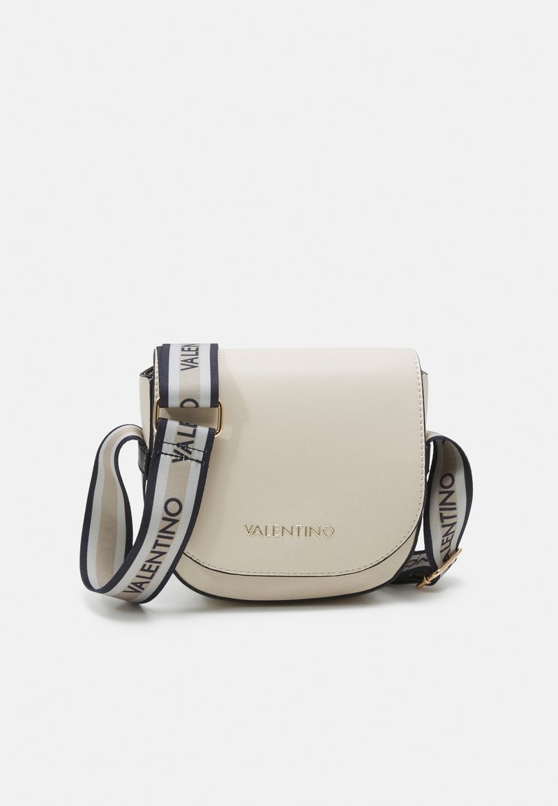 Borsa a tracolla in pelle beige con flap curvo, dotata di hardware dorato e di una tracolla regolabile con il marchio "VALENTINO" in blu navy.
