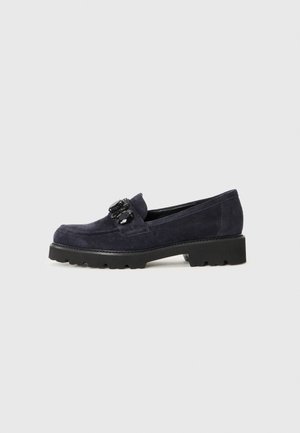 Donkerblauwe suède loafer met zwarte grove zool en decoratieve zwarte stenen op de bovenste band.