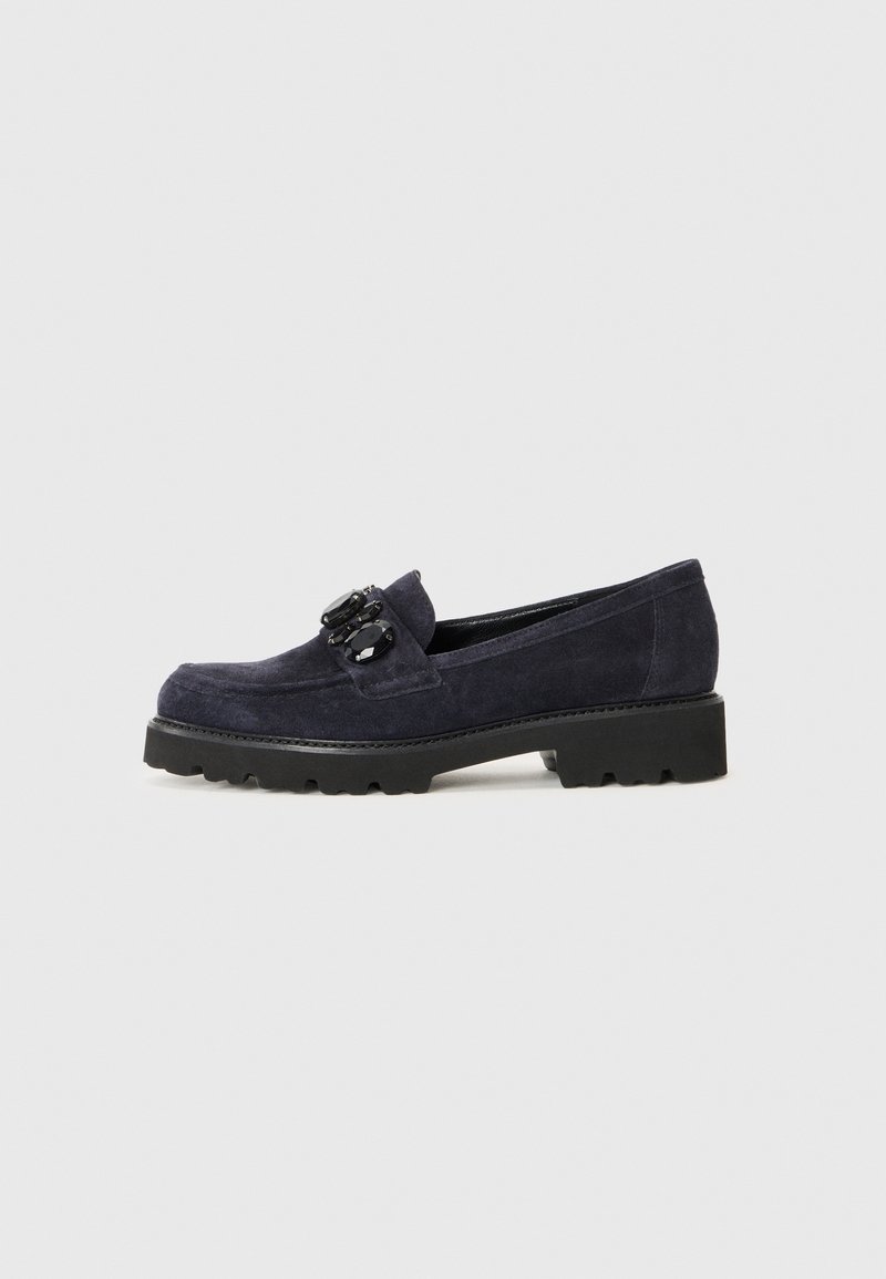 Mocassin en daim bleu foncé avec semelle épaisse noire et pierres décoratives noires sur la bande supérieure.