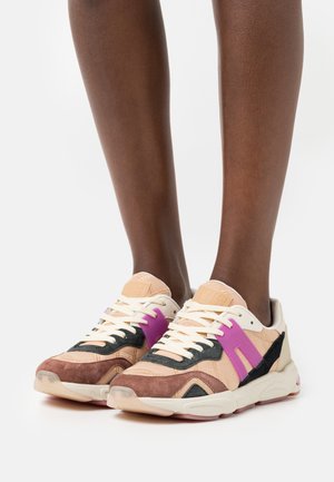 Sneaker mit einer Mischung aus hellbraunem, schwarzem und lila Wildleder sowie Leder. Das Design umfasst eine strukturierte Sohle und kontrastierende Schnürsenkel.