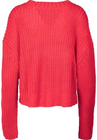 Lys rød chunky strikkegenser med lange ermer og ribbestrikket nederkant vist fra baksiden.