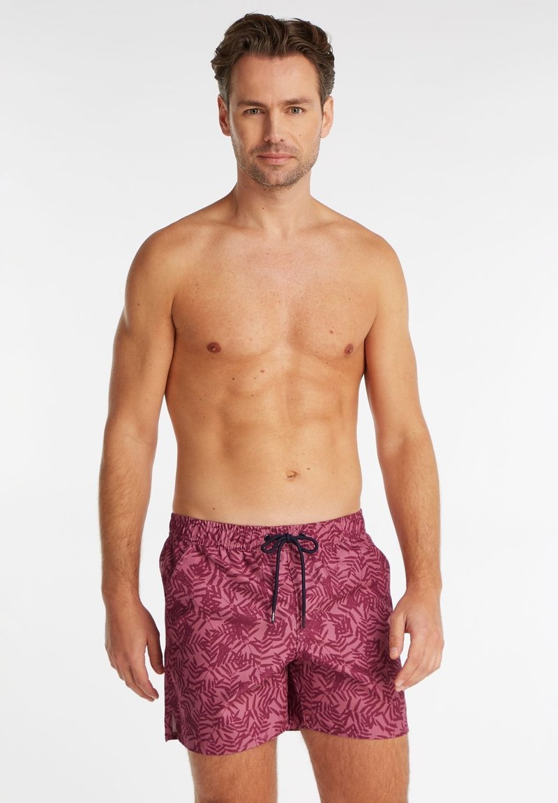Un short de bain bordeaux avec un motif de feuillage, doté d'une taille élastique et d'un cordon noir. Le tissu semble léger et doux.