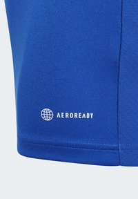 Blaues Sportshirt aus strukturiertem Stoff. Mit einem weißen "AEROREADY"-Logo und einem kreisförmigen grafischen Element. Das Design umfasst einen taillierten Schnitt und Nahtdetails.