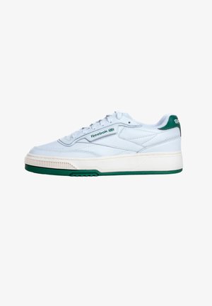 Λευκό αθλητικό παπούτσι Reebok με πράσινες λεπτομέρειες, σχέδιο με κορδόνια και λογότυπο της μάρκας στο πλάι και στη φτέρνα, εμφανιζόμενο σε προφίλ σε λευκό φόντο.