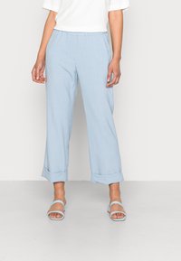 Pantalon bleu clair à jambes larges en tissu doux et texturé. Il présente un ourlet retroussé et une taille élastique pour plus de confort.