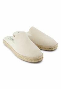 Světle béžové nazouvací boty vyrobené z měkké semišové kůže, s zaoblenou špičkou a podrážkou z juty pro přidanou texturu a přilnavost.