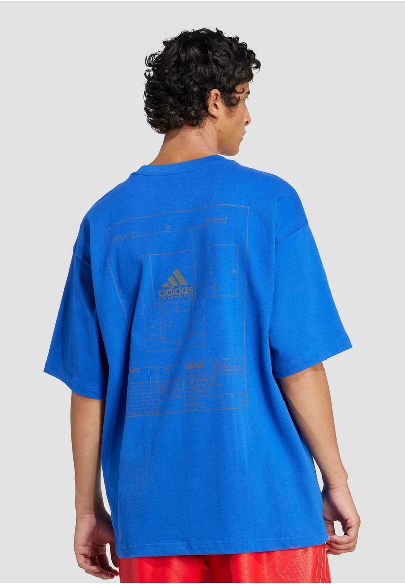 Blåt oversized t-shirt lavet af bomuld, med et guld grafisk tryk på ryggen, som viser tekniske designs og logoer.
