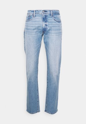 Jeans de ganga de azul claro com corte reto, cinco bolsos e fecho de botão. Apresenta áreas desbotadas e ligeiramente desgastadas.