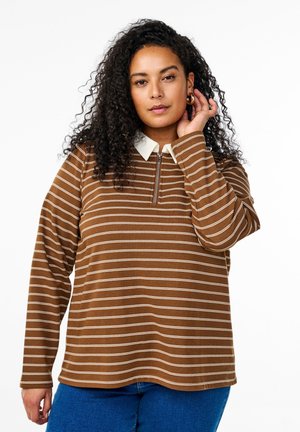 Chemise à manches longues rayée brune avec col à demi-fermeture éclair et détails blancs. Tissu doux, coupe décontractée et couture visible mettent en valeur le design.