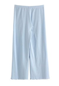 Vaaleansiniset leveälahkeiset housut, joissa on pystysuora nauhakuvio, joustava vyötärö ja hieman sahalaitaiset helmat, aseteltuna tasaisesti valkoista taustaa vasten.