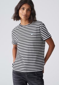 Zwart-wit gestreept T-shirt van katoen, met een ronde hals en een klein blauw hartlogo aan de linkerzijde.