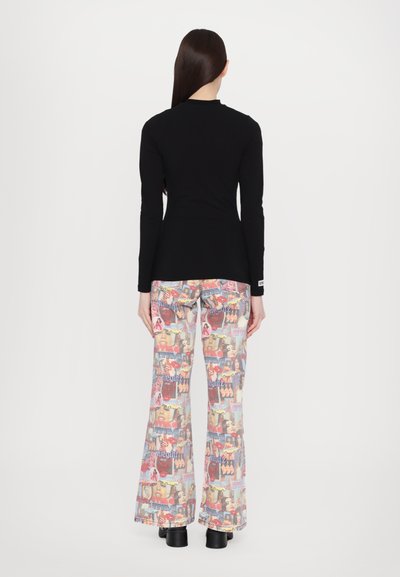 Top negro de manga larga y pantalones acampanados con un vibrante patrón gráfico de collage de rostros y texto. Tejido suave con un ajuste holgado.