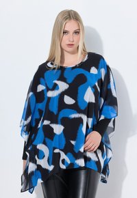 Top nero fluido con motivi astratti blu e bianchi. Presenta un colletto arrotondato e maniche ampie. Abbinato a leggings in pelle nera.