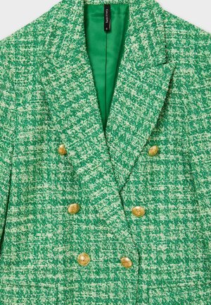 Blazer verde strutturato con design a doppiopetto, caratterizzato da bottoni dorati e una fodera verde liscia. Notevole motivo intrecciato e rever strutturati.