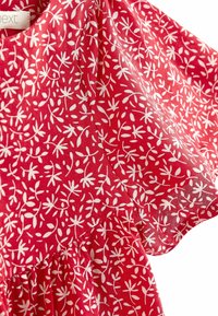 Rotes Kleidungsstoff mit weißen floralen und Blattmustern, kurzen puffärmel, und gerafftem Taillendetail.
