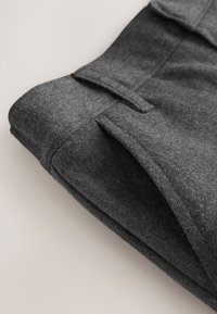 Graues Textilkleidungsstück mit glatter Textur, das ein gefaltetes Design und subtile Nähte aufweist. Kein sichtbares Zubehör oder Muster.