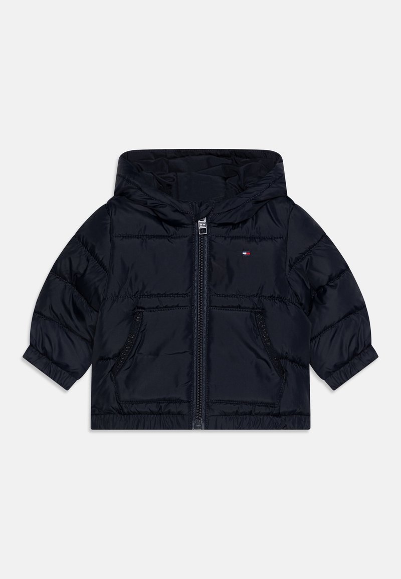 Veste matelassée à capuche bleu marine avec fermeture éclair à l'avant, deux poches zippées, poignets élastiques et petit logo brodé sur le côté gauche de la poitrine.