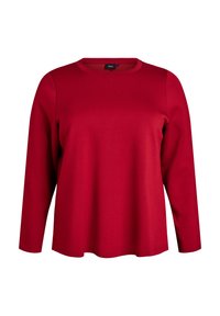 Crvena majica dugih rukava od mekog materijala. Ima okrugli izrez i ležeran kroj. Glatka tekstura bez vidljivih uzoraka ili akcenta.