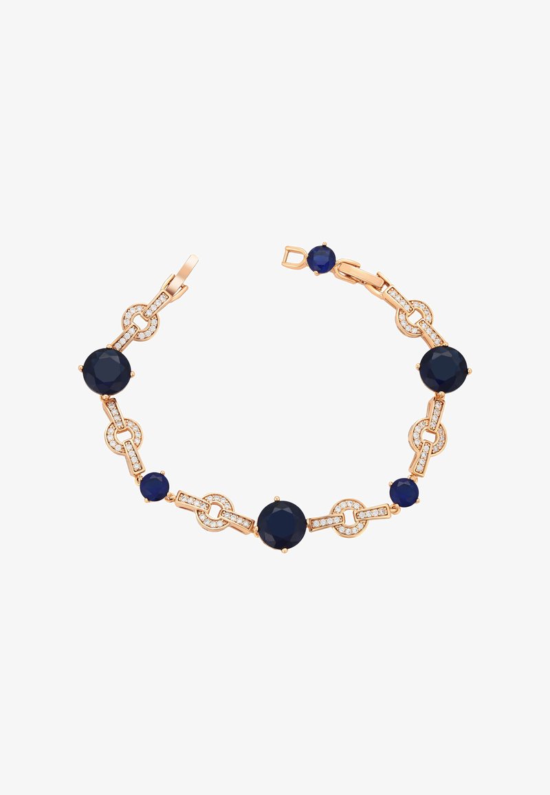 Auksinės spalvos apyrankė su tamsiai mėlynais apvaliais akmenimis ir skaidriais akcentiniais akmenimis, susijungusiais puošniomis grandinės detalėmis. Uždarymas su sagtimi.