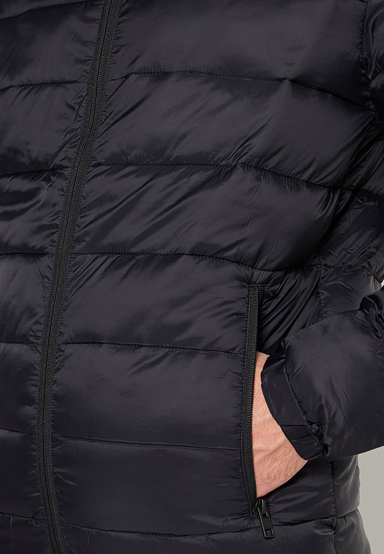 Czarna kurtka puchowa z pikowanym wzorem, zamkiem błyskawicznym i bocznymi kieszeniami. Materiał wydaje się lekki i gładki, z błyszczącym wykończeniem.