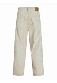 Light beige high-waisted wide-leg trousers, featuring a solid texture, five-pocket design, and a leather patch accent on the back.