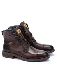 Brown leather ankle boots with mesh paneling, round toe, laces, and a textured finish. Features a tan accent label on the side.