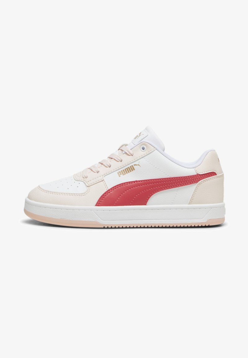 Sapatilhas PUMA com um cabedal de couro branco e rosa claro, risca lateral vermelha, fecho com atacadores e sola de borracha texturizada. Detalhe de marcação a ouro.