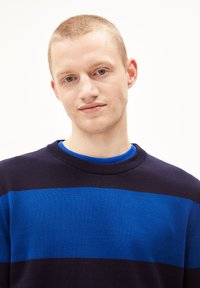 Navyblau und königsblau gestreifter Pullover mit rundem Hals, aus einem glatten Strickstoff gefertigt, mit einer lockeren Passform und gerippten Bündchen.