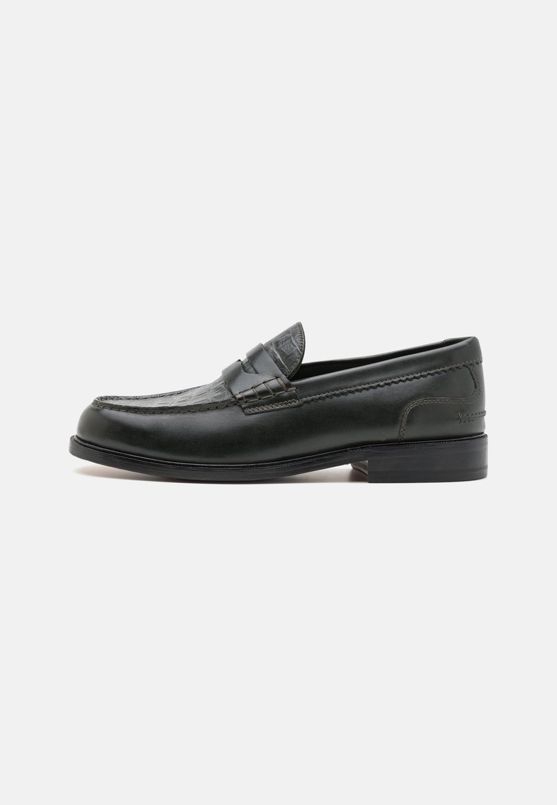 Schwarze Lederloafers mit runder Zehenform, dekorativen Nähten und einem strukturierten Akzentpanel. Niedriger gestapelter Absatz, elegantes Design und glatte Oberfläche.