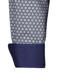 Polsino di camicia da dress navy con un tessuto decorato che presenta disegni circolari bianchi; texture liscia e forma strutturata.