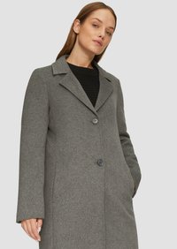 Manteau en laine gris avec un col à revers, fermeture à double bouton et manches longues. Texture lisse avec poches latérales, silhouette ajustée.