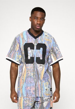 Kortærmet trøje med et flerfarvet abstrakt mønster, sorte detaljer og et stort sort "C3" print på forsiden. V-udskæring.