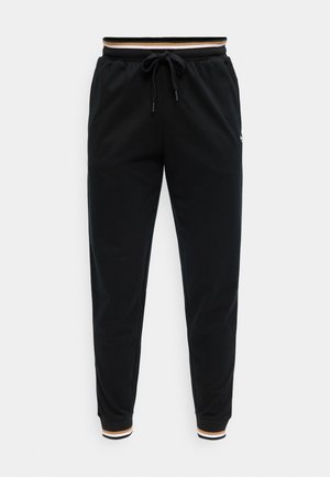 Pantaloni jogger neri a gamba affusolata con vita elastica e coulisse, con polsini a coste a righe beige e bianche e bordatura in vita.
