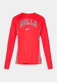 Rød langærmet atletisk skjorte med "BULLS" tekst i sort og hvid, med et Nike-logo og hvide sidestriber. Glat tekstur, sporty design.