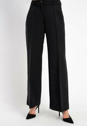 Schwarze weit geschnittene Hose aus glattem Stoff mit Seitentaschen und einem Knopfverschluss vorne. Der Saum ist sauber verarbeitet und ergänzt hohe Absätze.