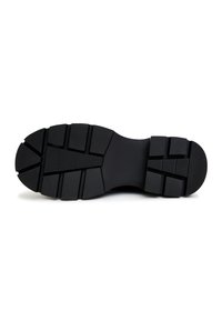 Sole di scarpa nera con una superficie testurizzata e rigata. Presenta scanalature profonde per una buona aderenza e una forma larga e robusta per la stabilità.