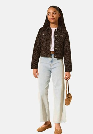 Pige med langt hår bærer en leopardmønsterjakke, hvid top, lyseblå vidde jeans, brune flade sko og holder en lille brun håndtaske.