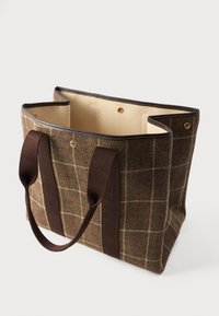Καφέ καρό τσάντα tote με πλατιές σκούρες καφέ λαβές και μπεζ εσωτερικό, ανοιχτή με τις κλειστες κουμπί snap ορατές μέσα.